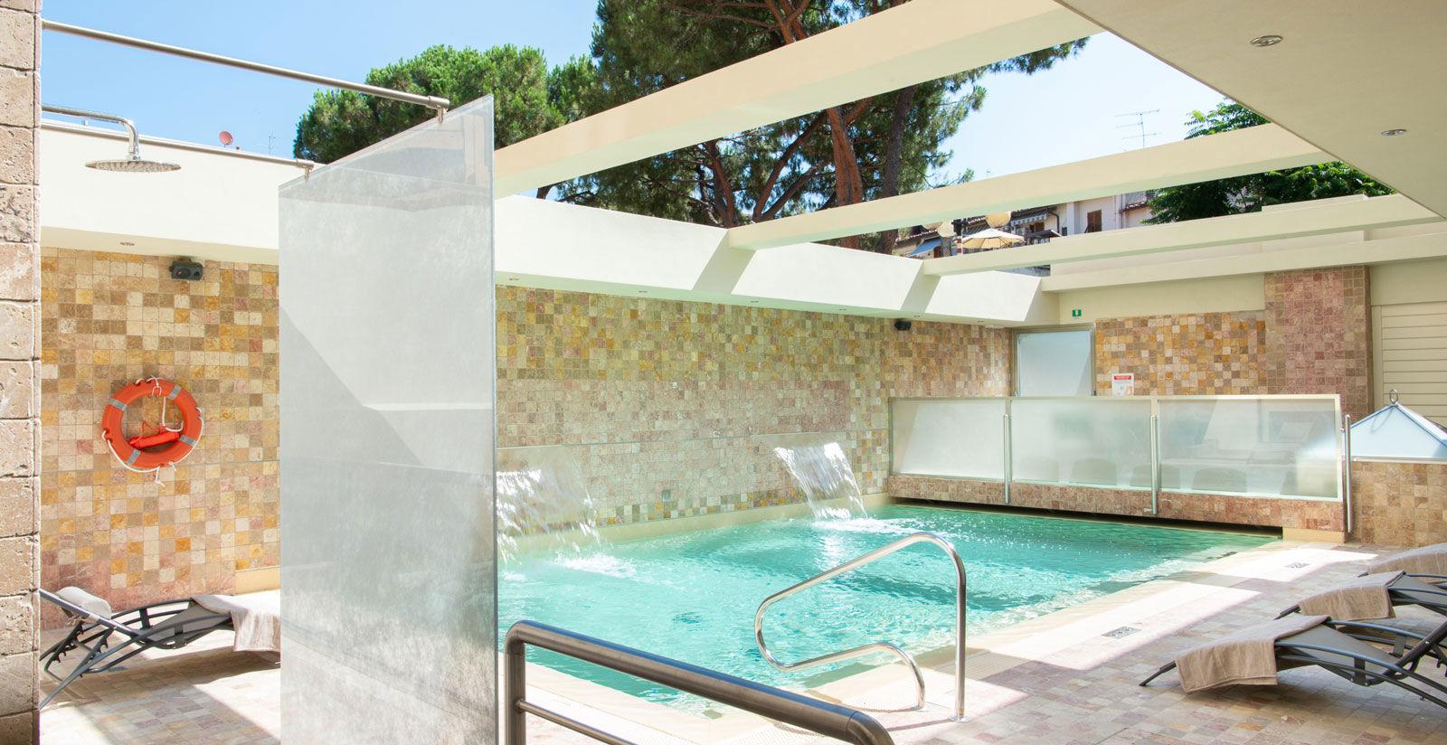 Vista della vasca interna con acqua limpida e area relax adiacente