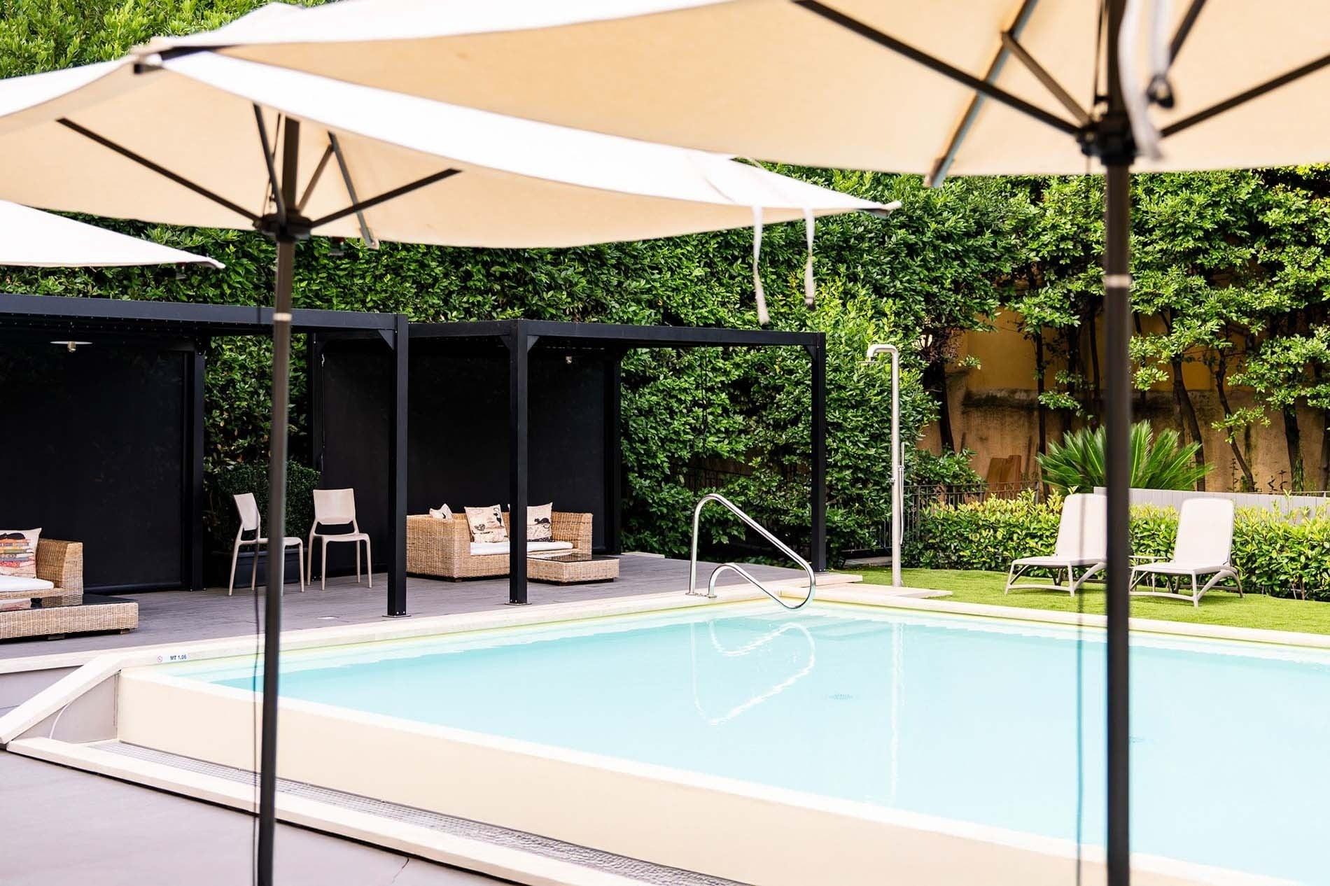 una grande piscina circondata da sedie e ombrelloni