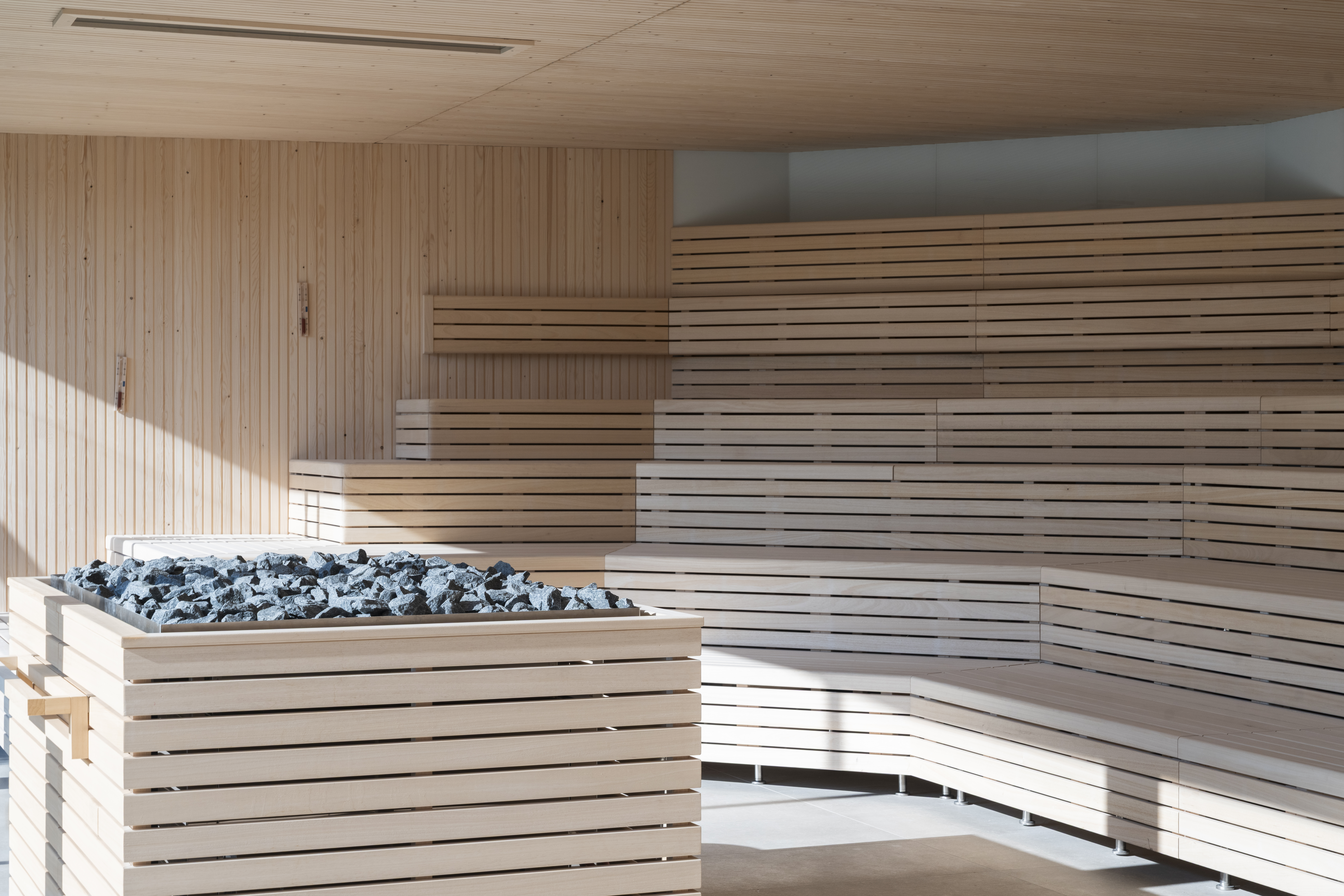 Interno di una sauna in legno con pietre calde in una day spa