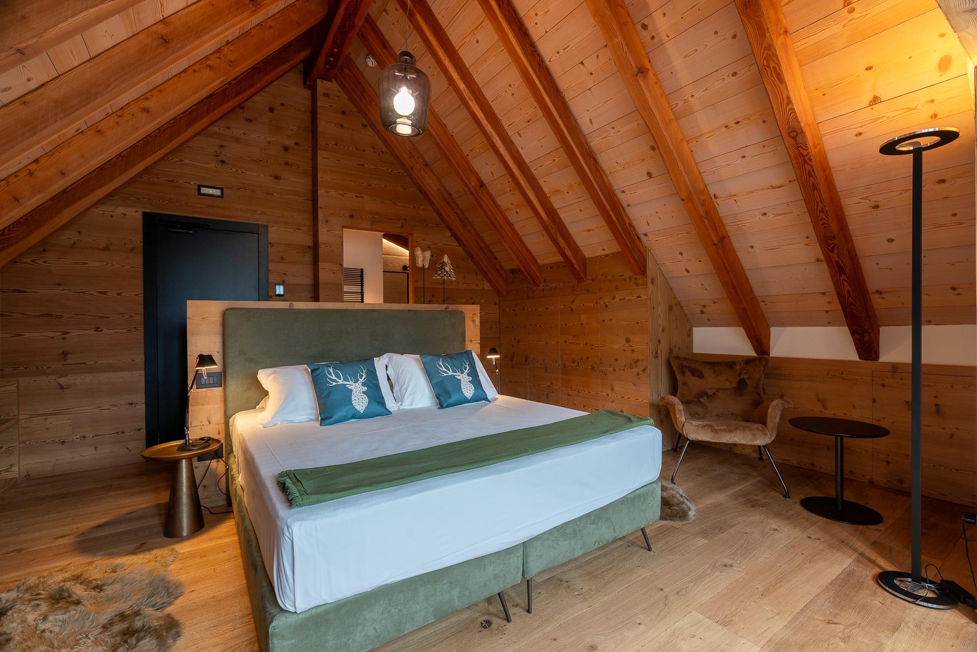 Camera mansardata con travi a vista in legno