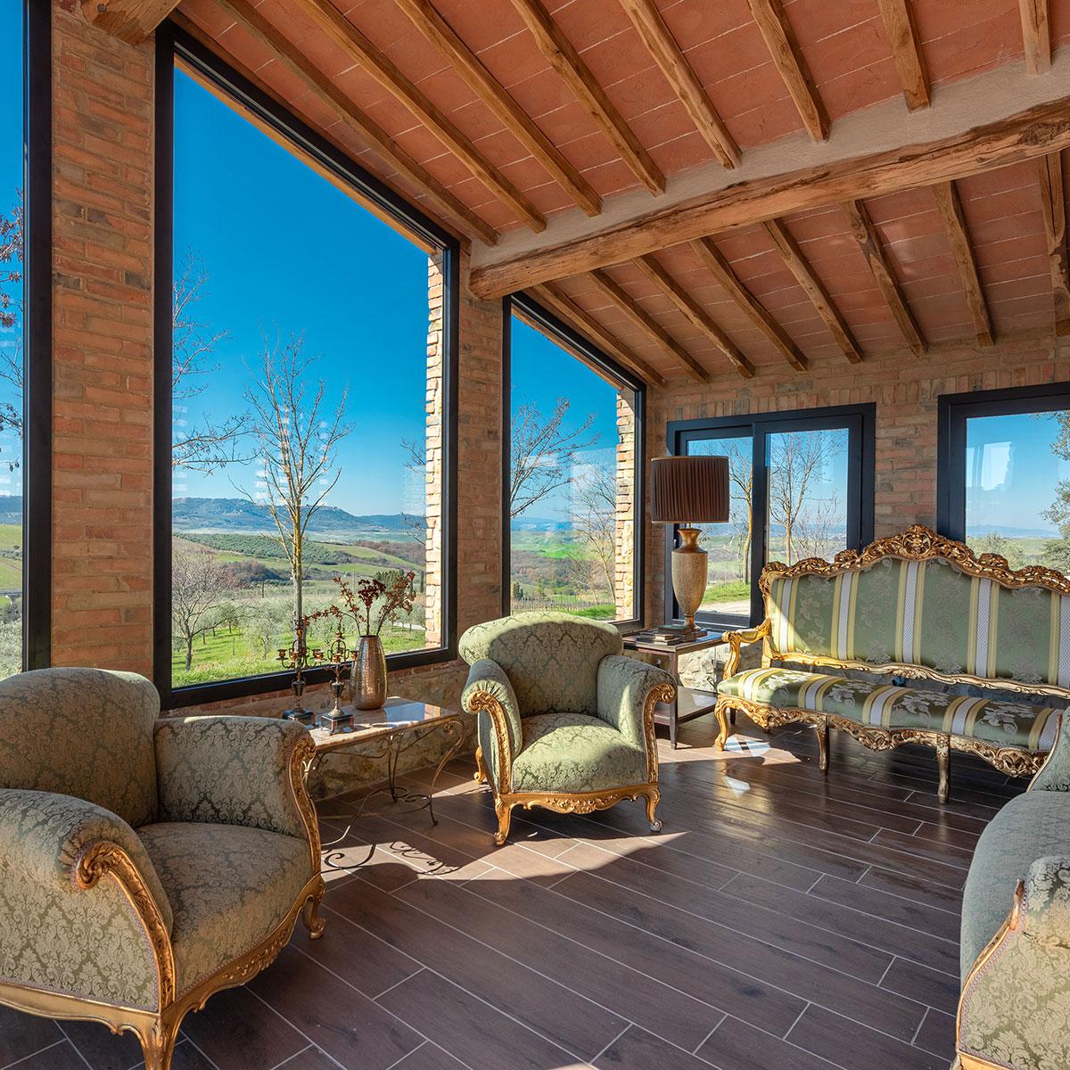 Lounge elegante con arredi storici e panorama toscano