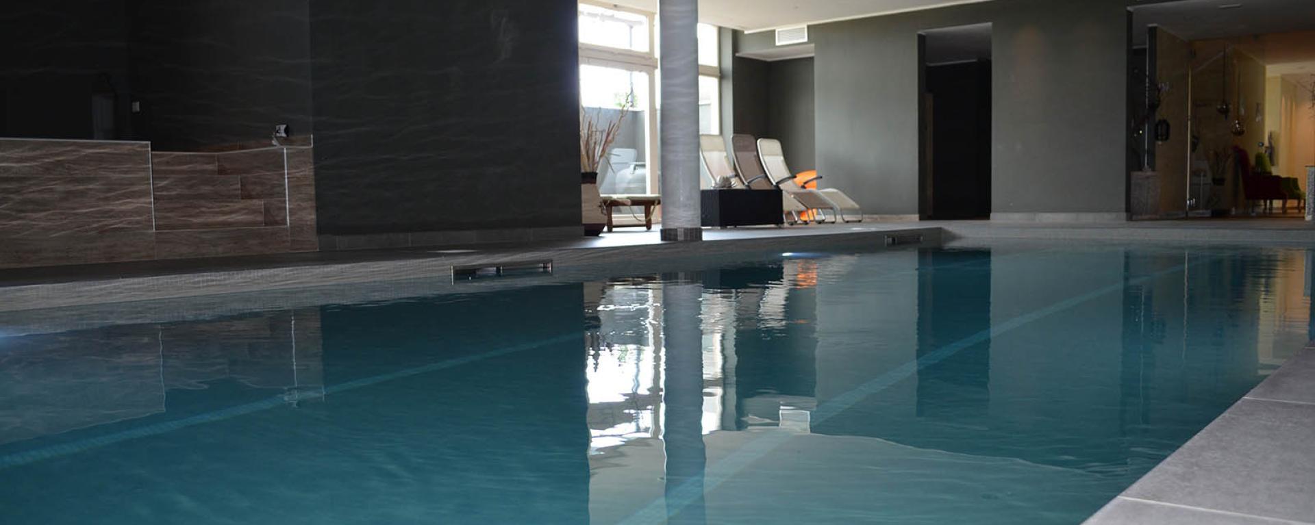 Piscina interna elegante con acqua calma e sedie a sdraio accoglienti