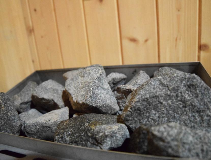 Pietre in sauna con atmosfera rilassante in legno chiaro