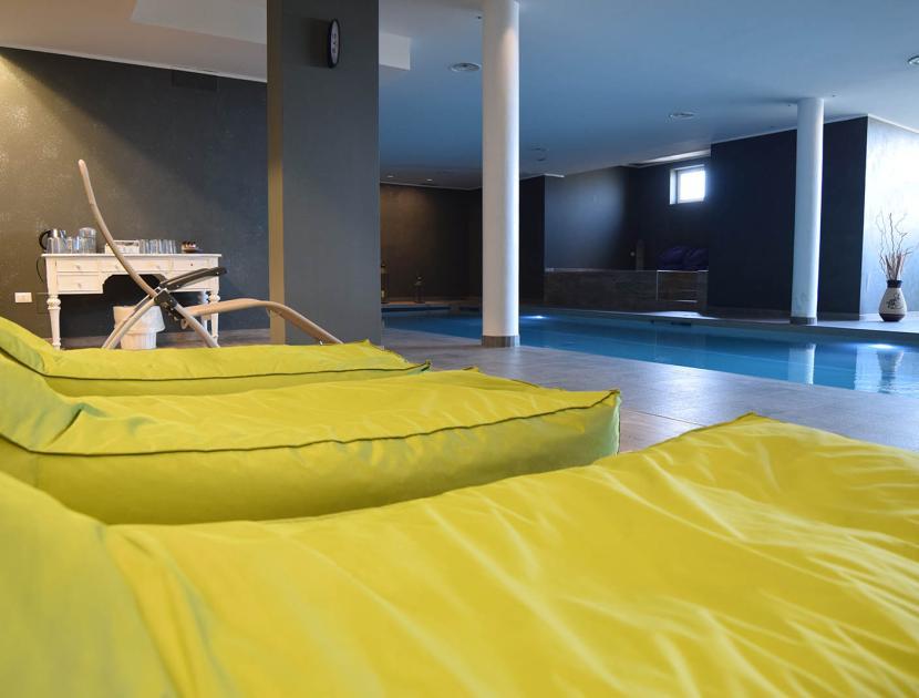 Piscina coperta elegante con lettini verdi