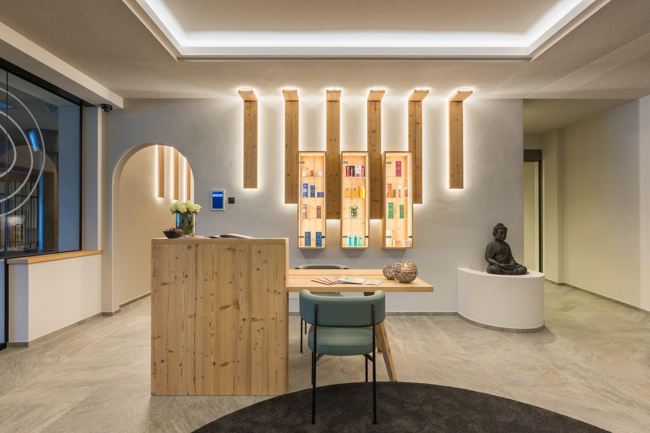 Reception con bancone in legno, sedie e illuminazione decorativa