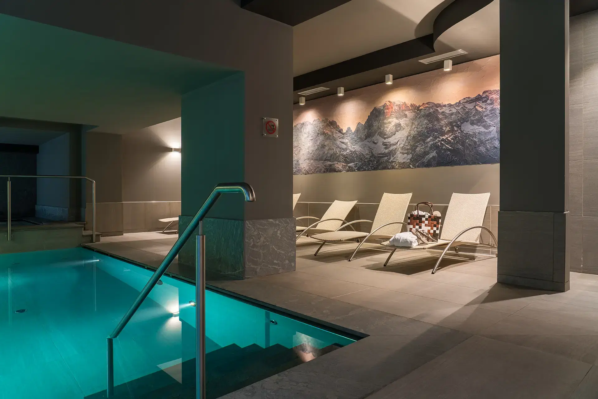 Area relax con piscina interna e lettini in un ambiente moderno e accogliente