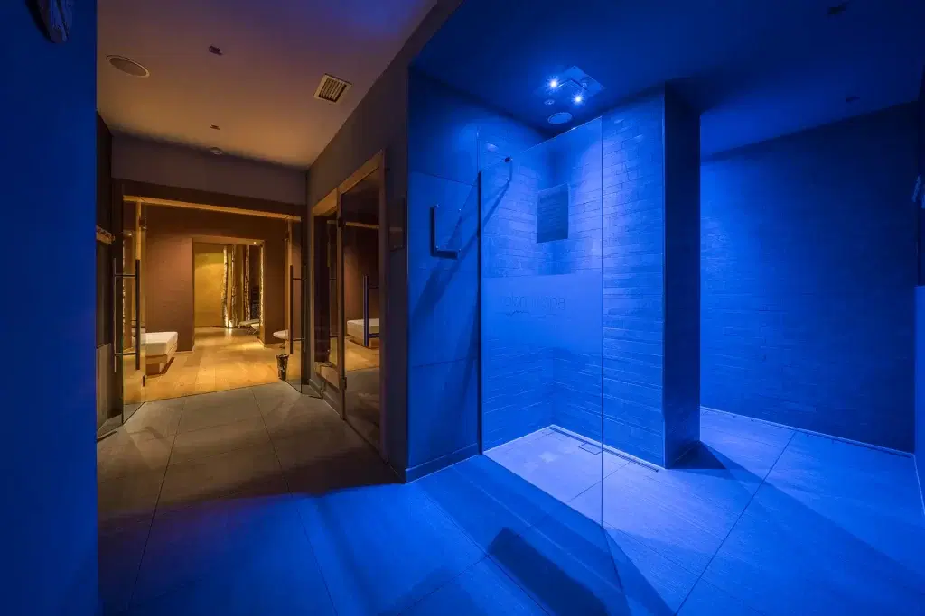 Corridoio di una spa con illuminazione blu e zona relax
