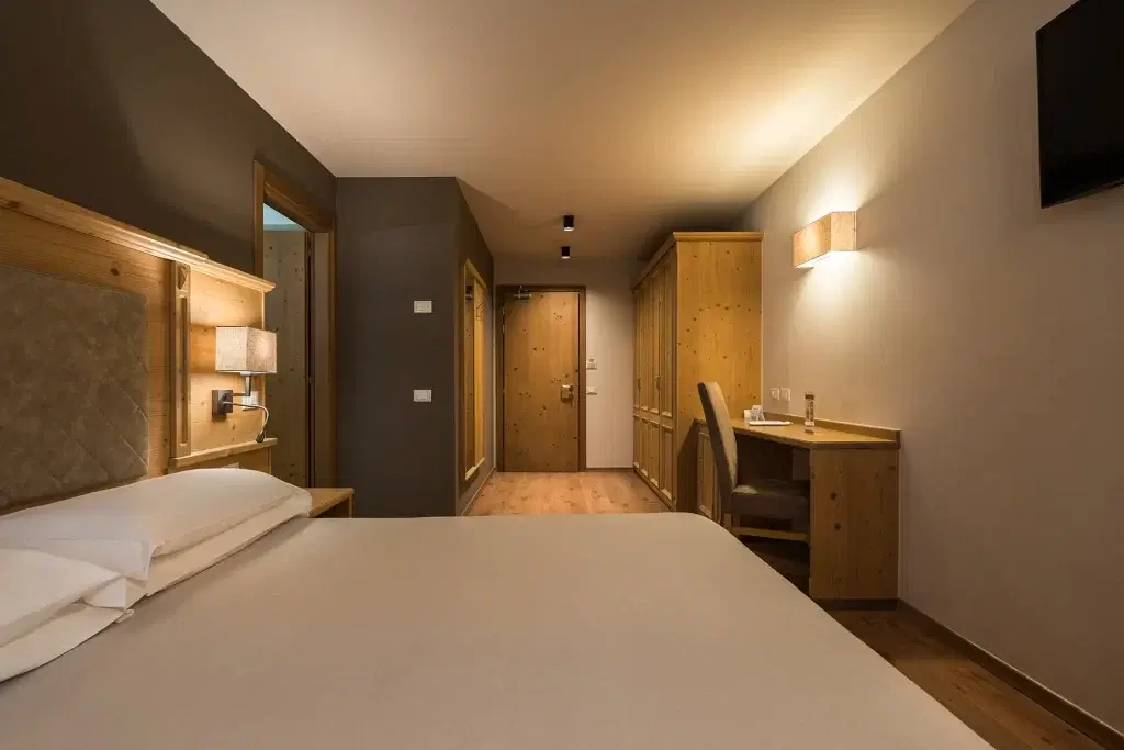 Camera d'albergo accogliente e moderna con arredi in legno e illuminazione soffusa