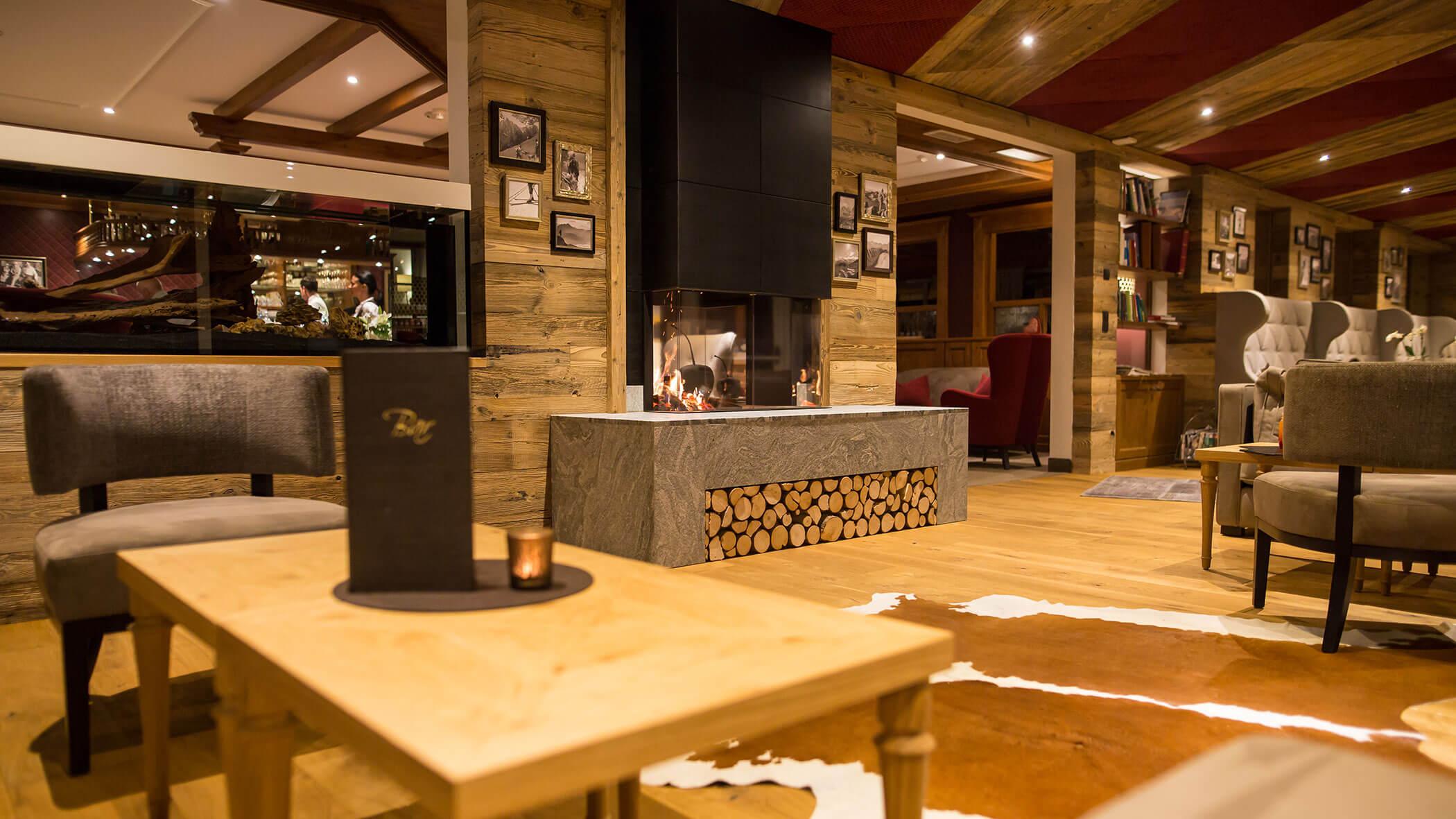 Salotto accogliente con arredamento in legno, camino, mobili moderni e illuminazione calda