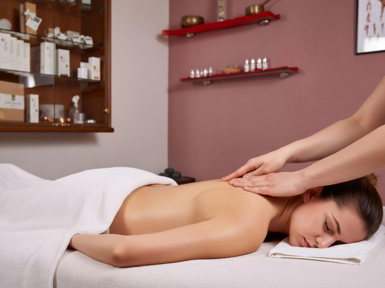 Donna sdraiata a faccia in giù su lettino da massaggio che riceve massaggio alla schiena