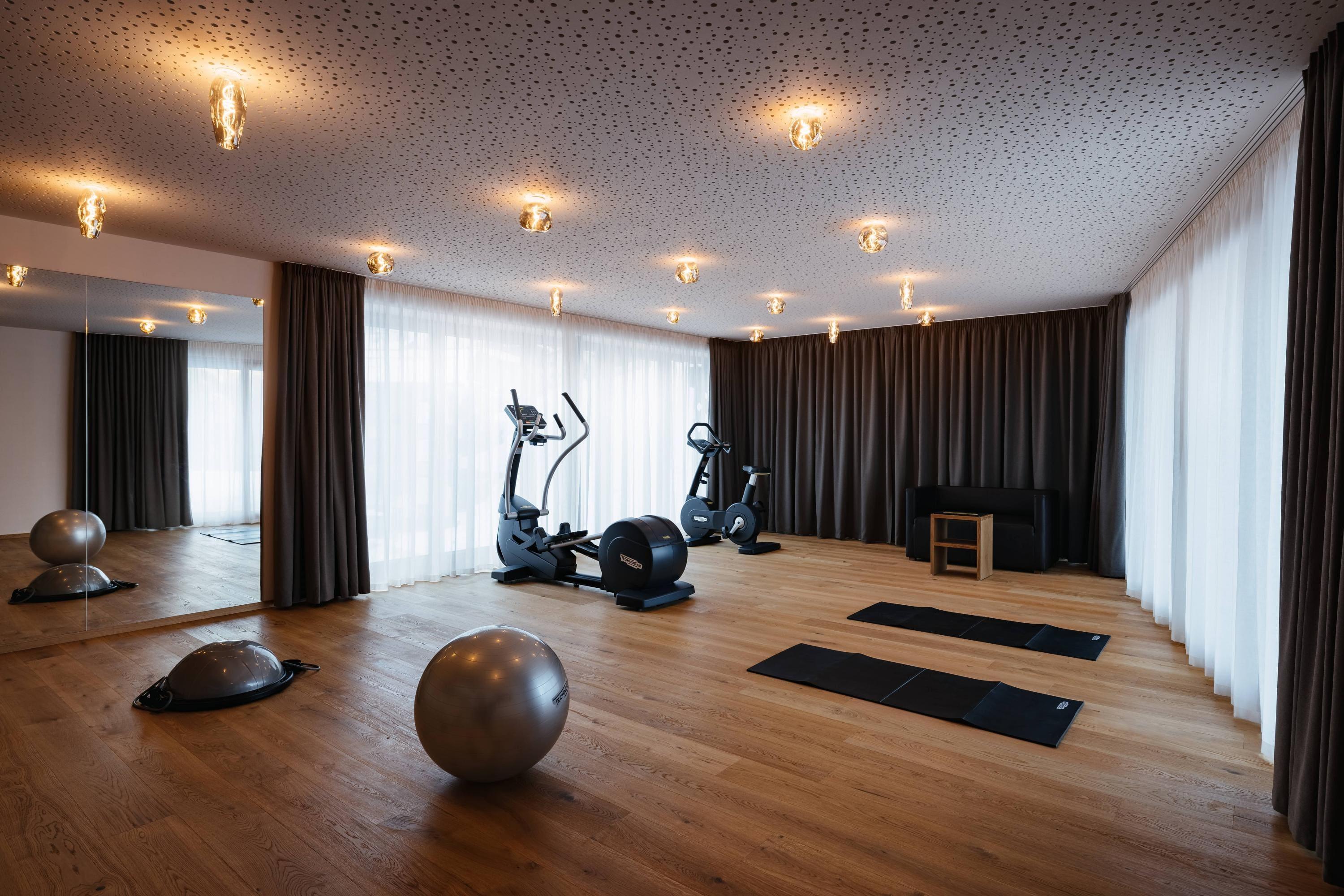 Sala fitness con tappeti e vista sulla montagna