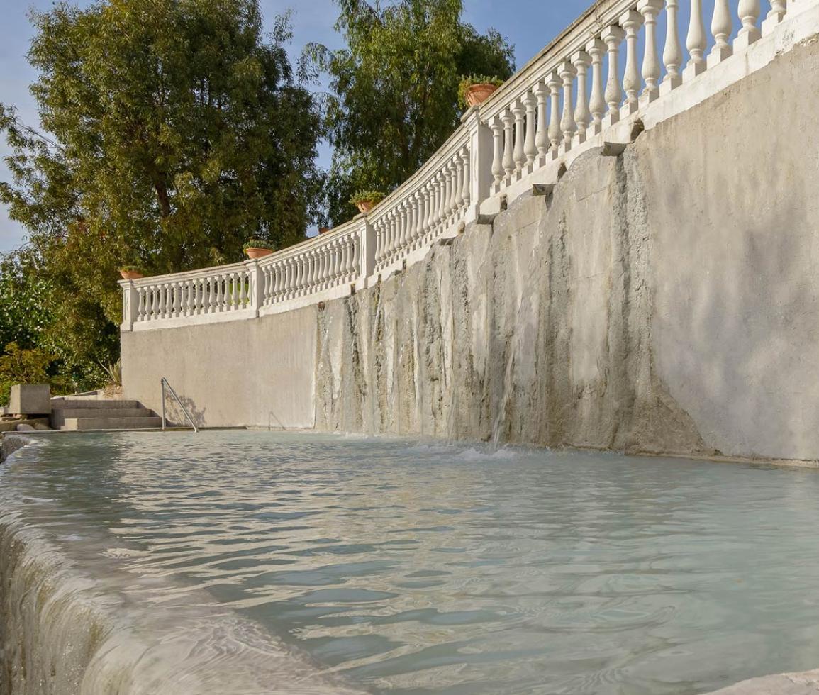 Piscina termale con cascata, atmosfera rilassante e naturalezza serena