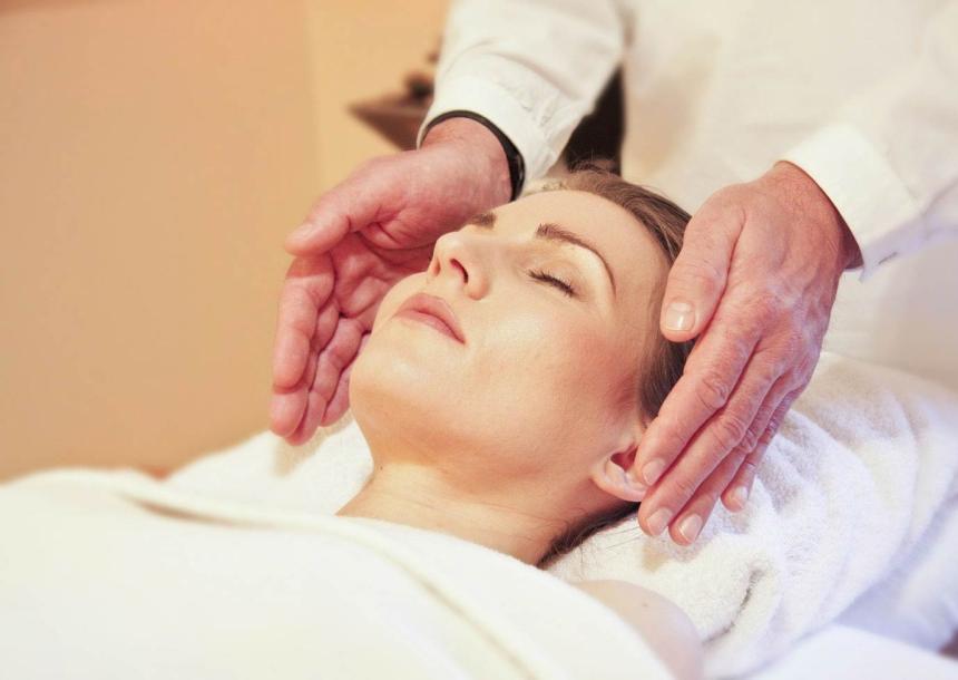 Un momento di rilassamento e cura, mani gentili sopra un viso sereno