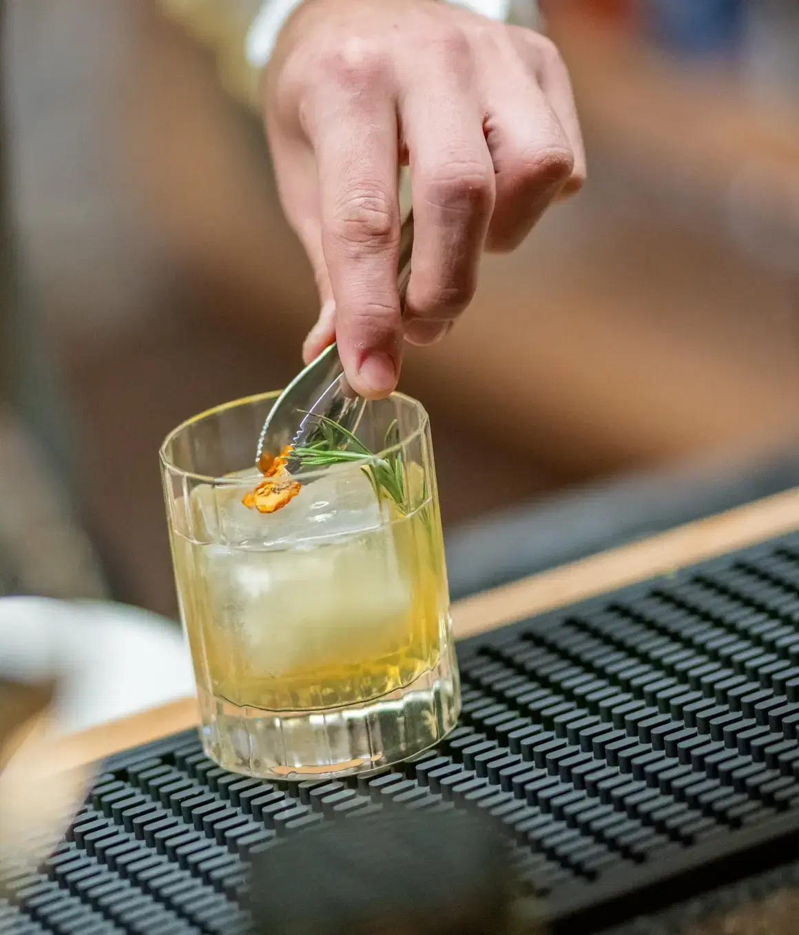 Cocktail artigianale con rosmarino e scorza d'agrume