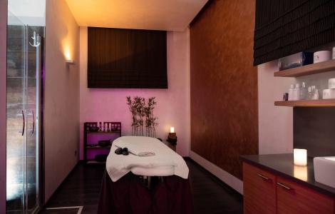 Sala massaggi rilassante con luci soffuse, candele accese e ambiente caldo accogliente