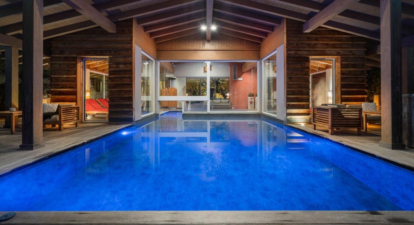Piscina interna con acqua blu e pareti in legno