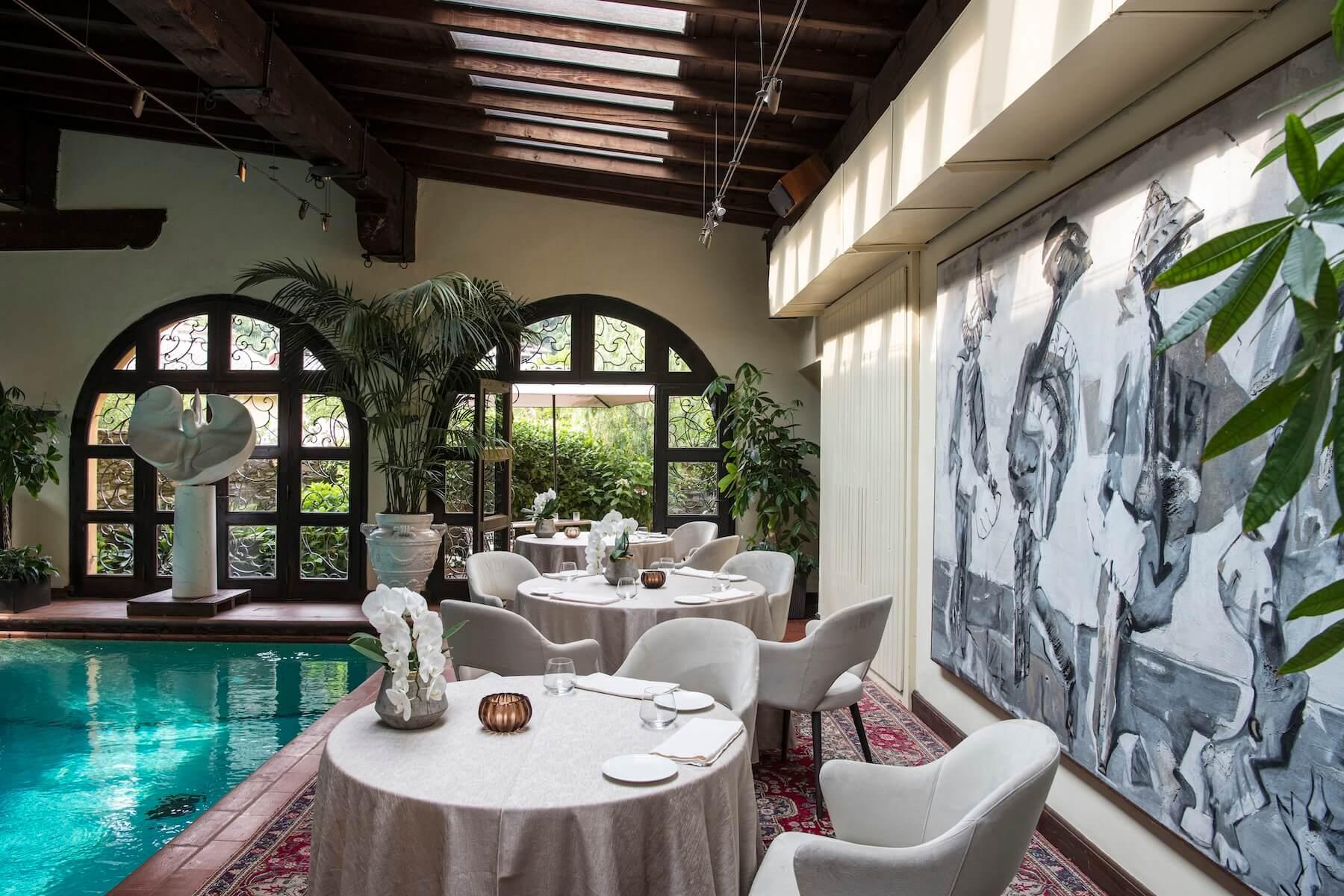 Sala della Piscina con specchio d'acqua centrale e travi lignee adibita alla spa