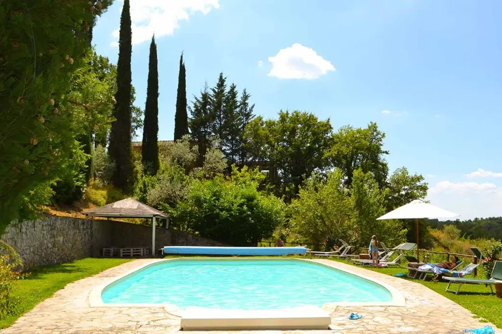 Piscina esterna panoramica con lettini e vista sui vigneti