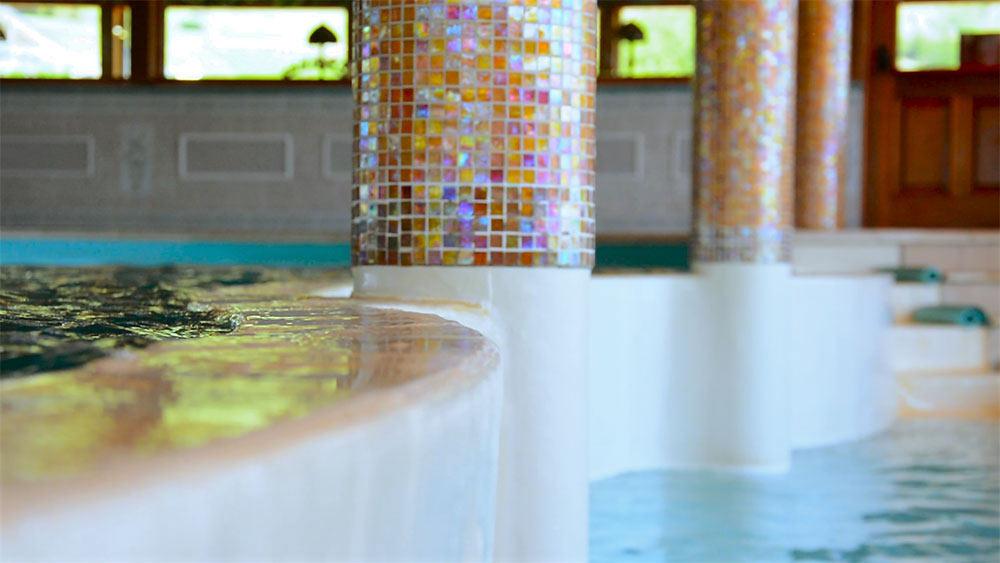 Piscina principale interna con vasca idromassaggio e vista sulle montagne innevate