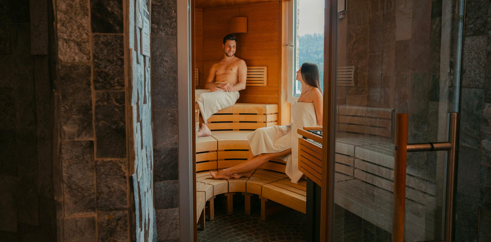 Coppia che si rilassa nella sauna panoramica del Parc Hotel Du Lac