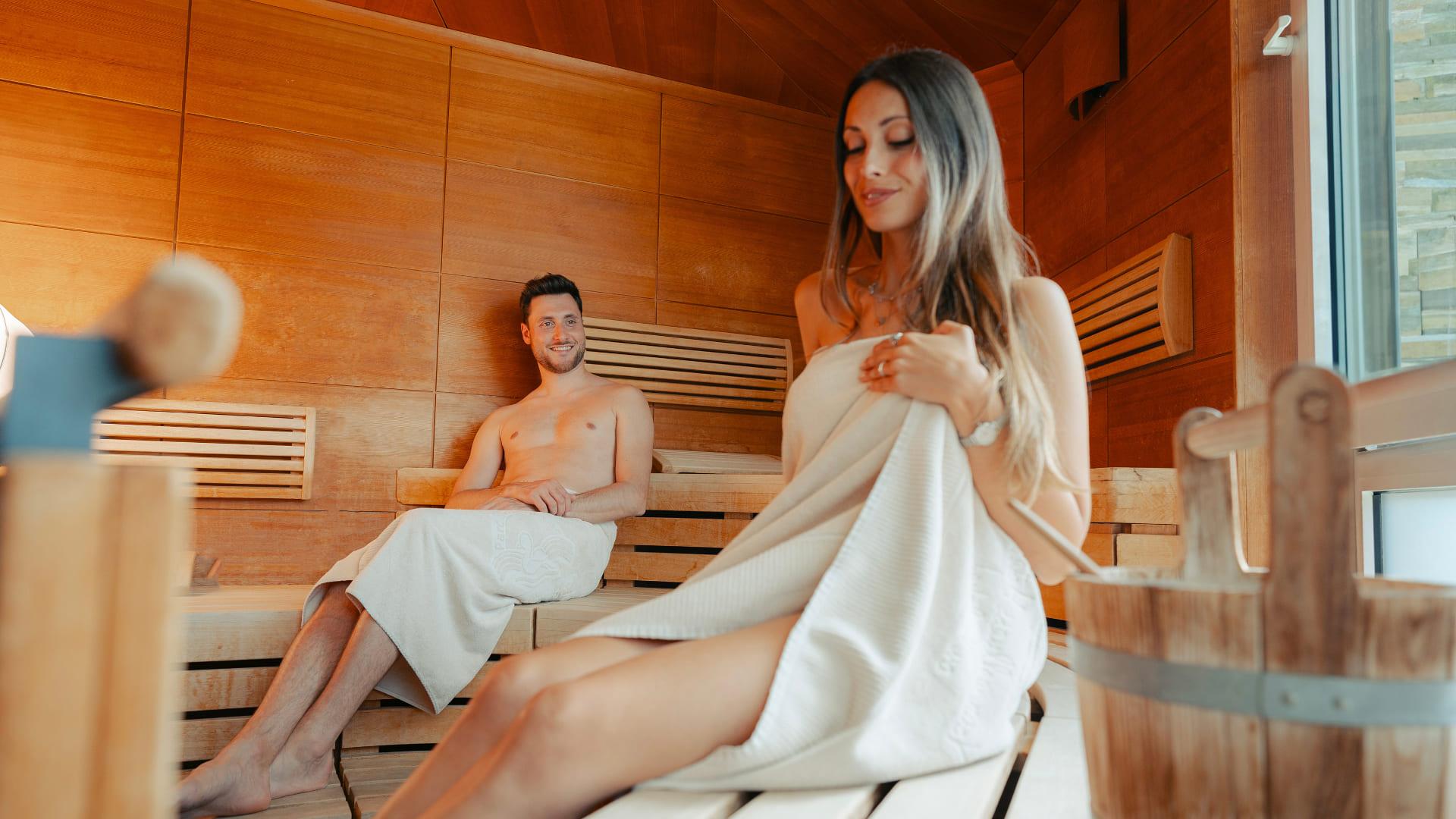 Coppia che si rilassa nella sauna panoramica con vista sul Lago di Levico