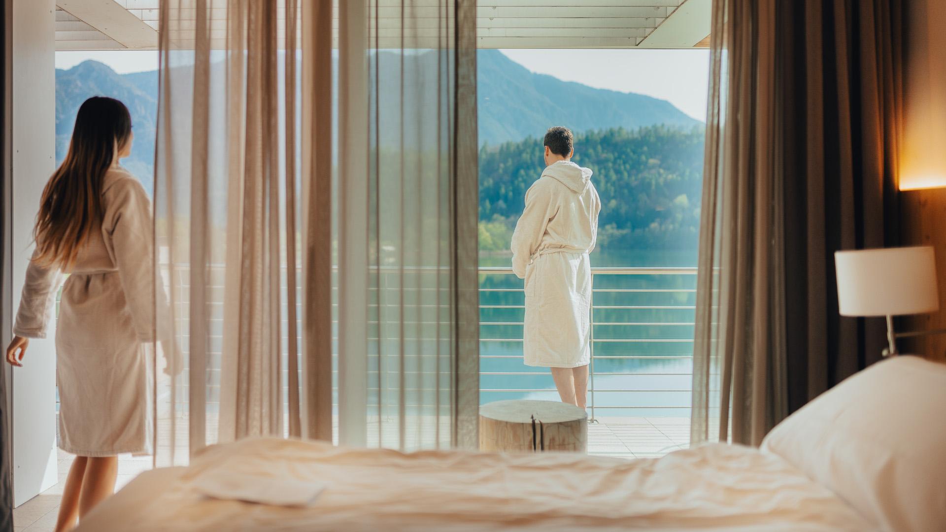 Coppia che ammira il panorama del lago dal balcone della camera d'hotel