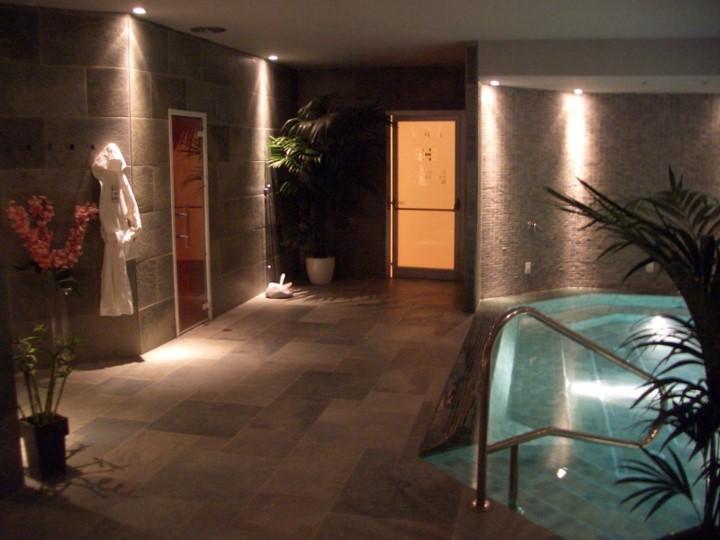 Area spa con piscina interna illuminata e ambiente rilassante