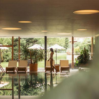 Donna nella piscina coperta con vista sul parco circostante