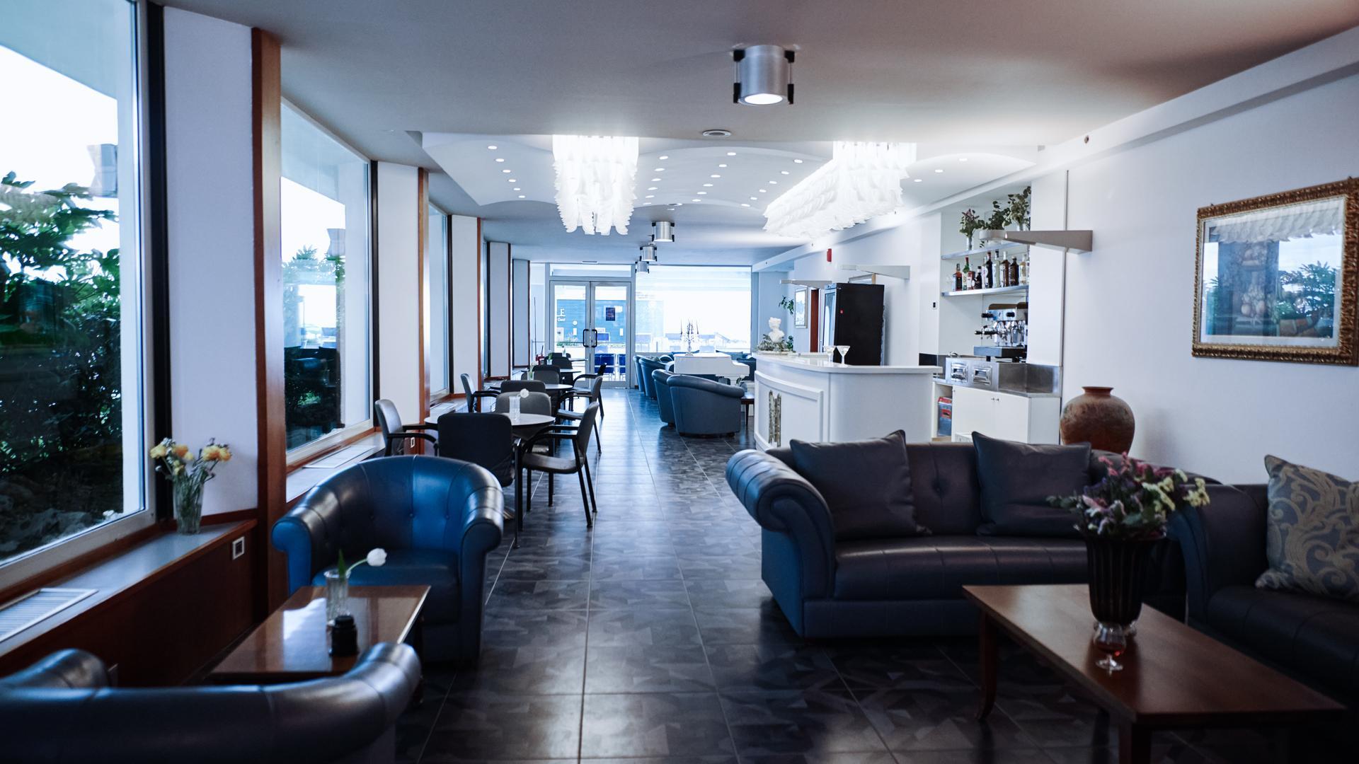 Elegante lounge con divani, tavoli e bar luminoso