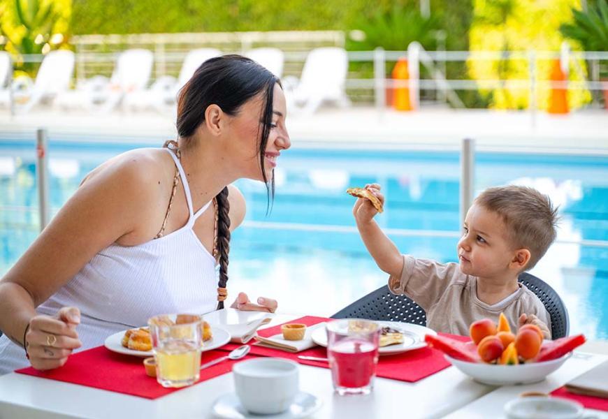 Colazione all'aperto vicino alla piscina con madre e figlio