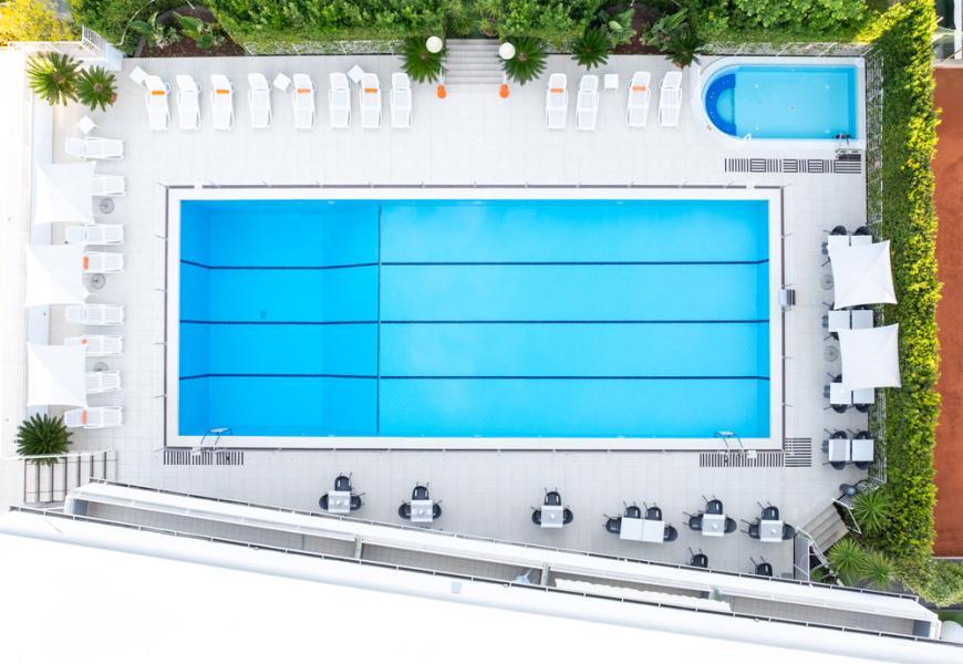 Vista dall'alto di una piscina all'aperto con lettini e ombrelloni