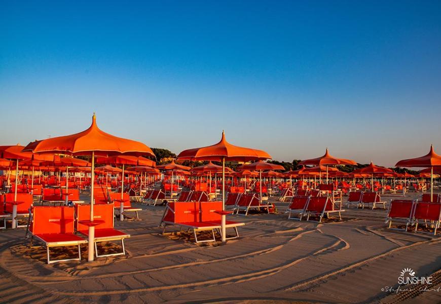 Spiaggia con ombrelloni arancioni al tramonto
