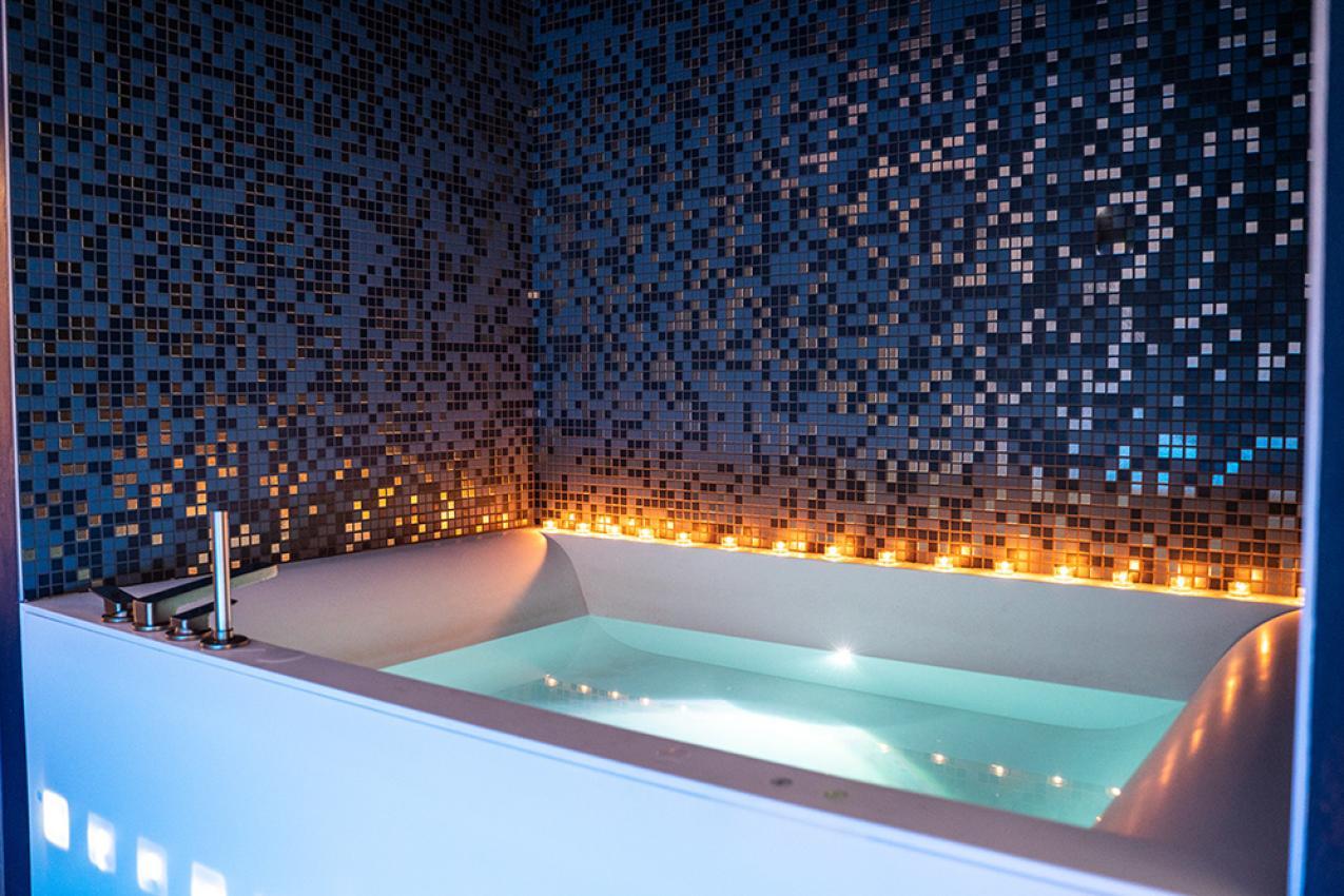 Vasca da bagno moderna con mosaico blu e candele