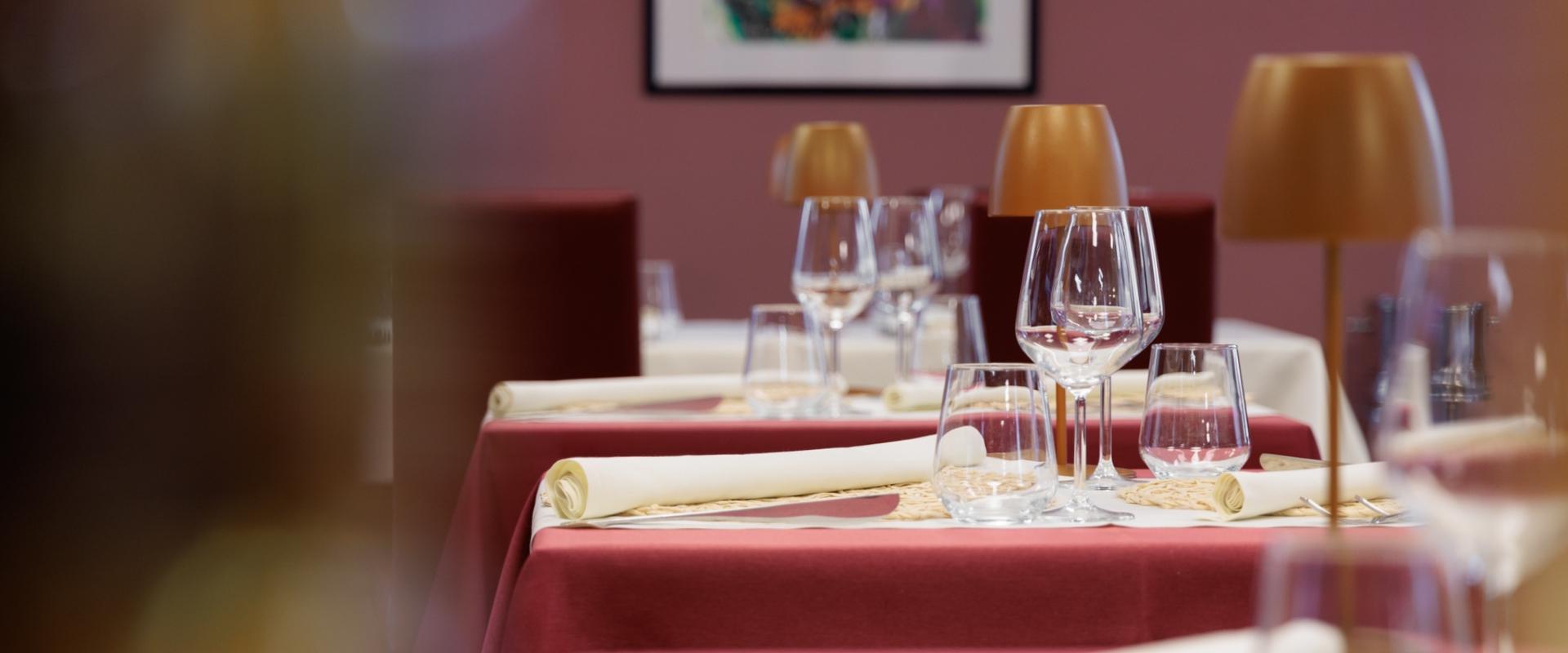 Tavoli apparecchiati con bicchieri e tovaglioli in un elegante ristorante