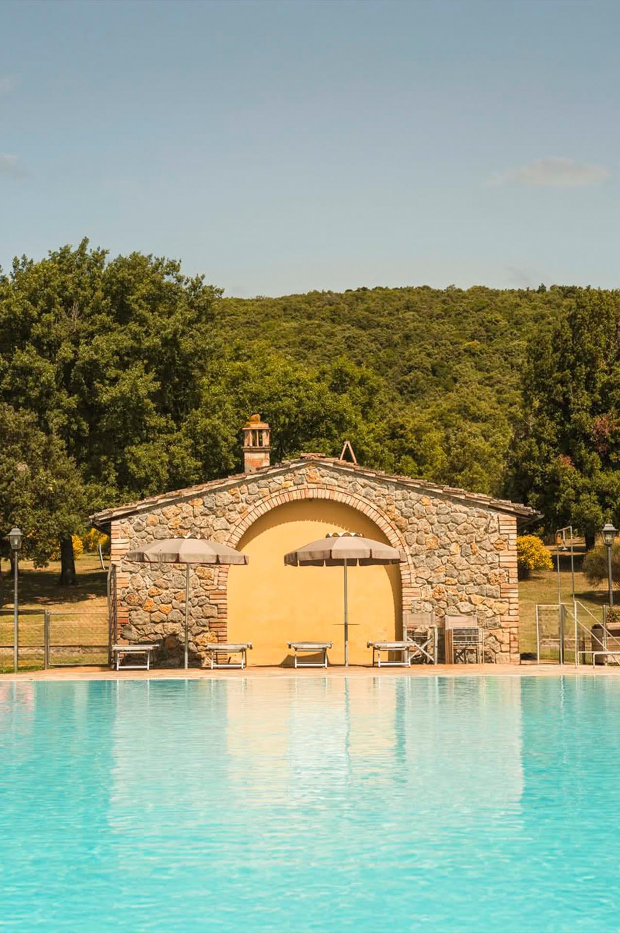 Vista del parco e della piscina del Casolare Le Terre Rosse