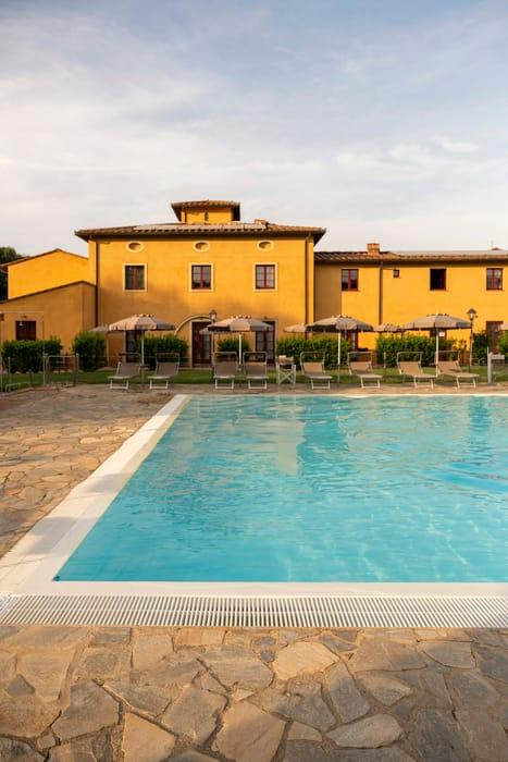 Solarium della piscina con lettini e ombrelloni