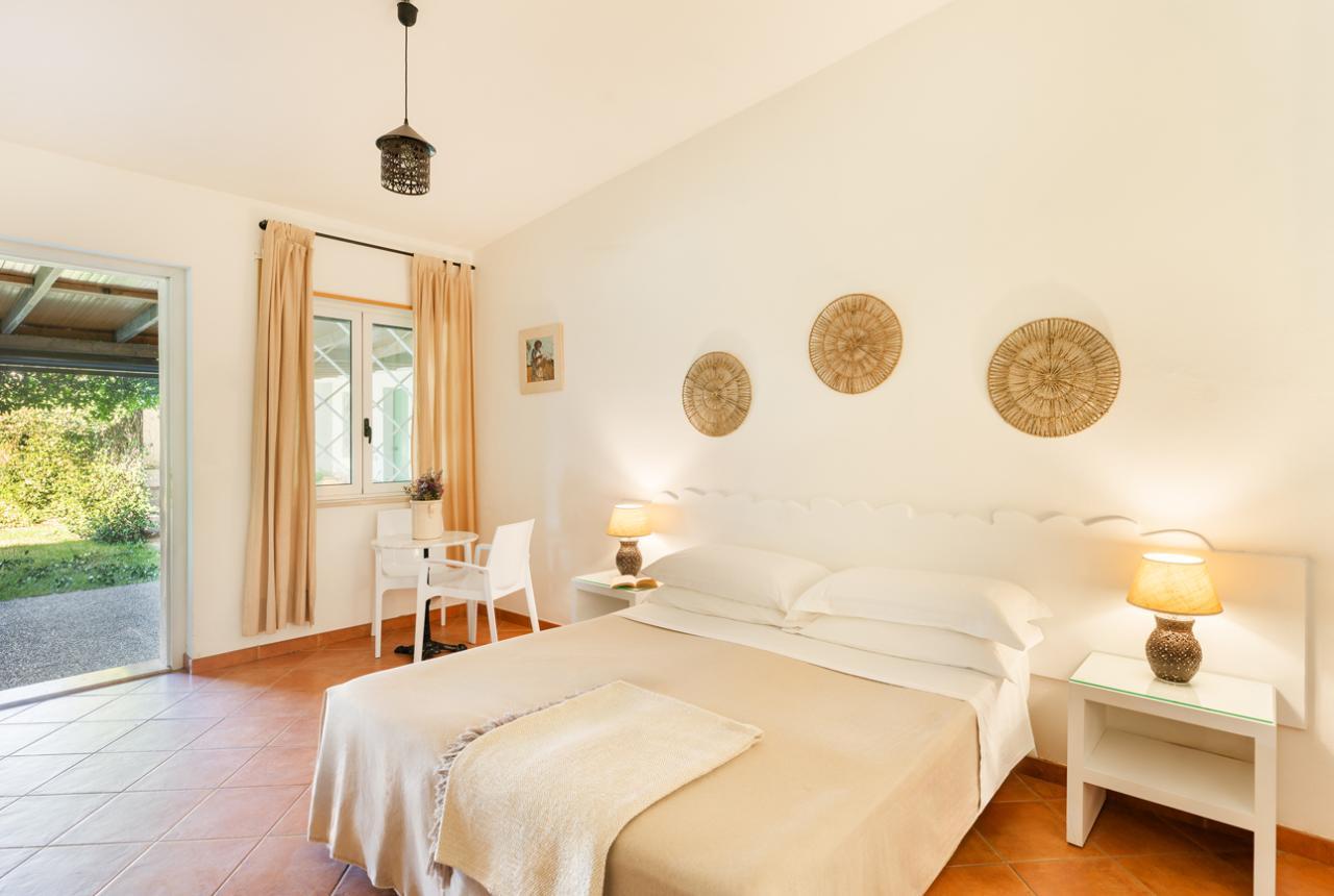 Camera luminosa con letto matrimoniale e decorazioni naturali