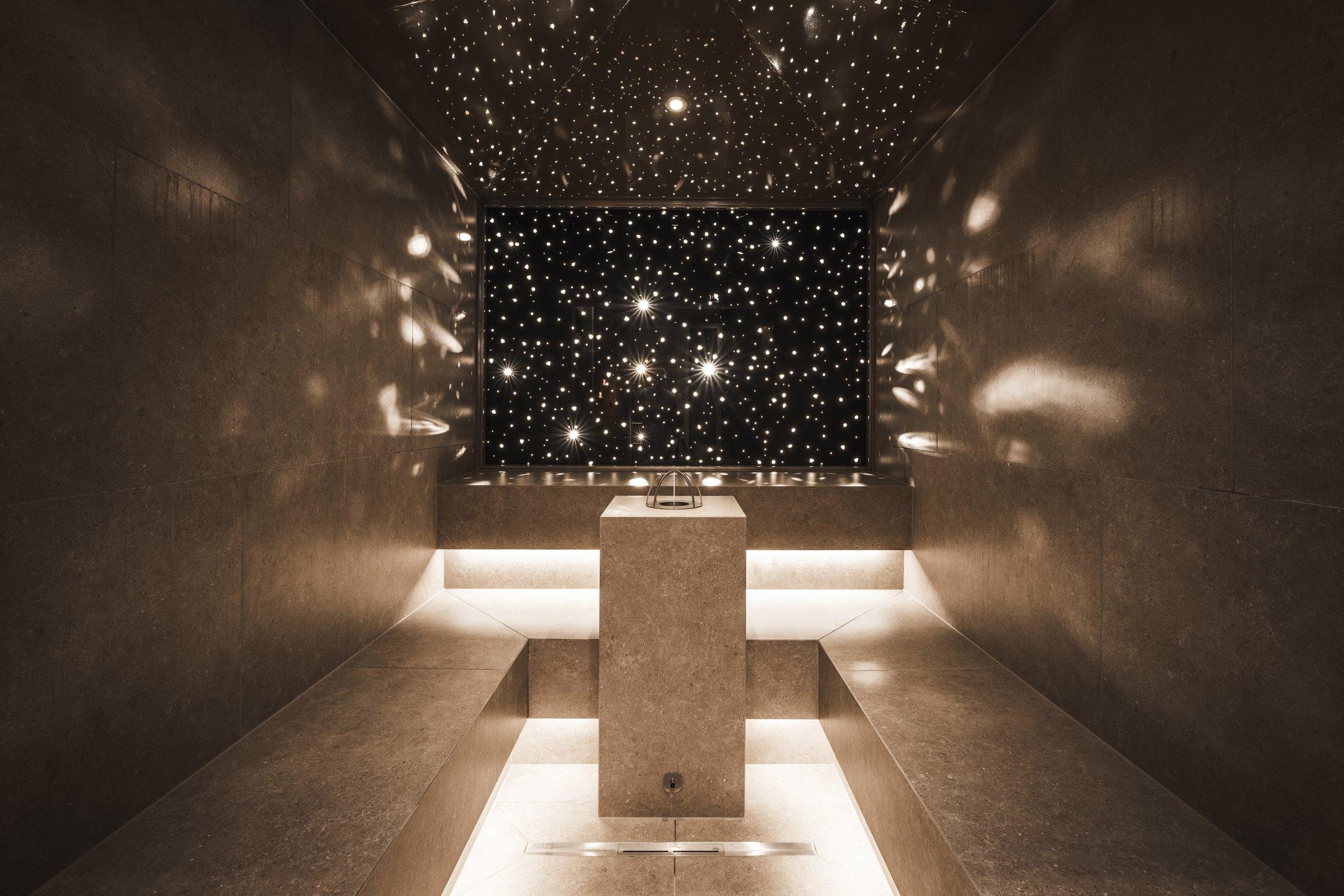 Bagno di vapore moderno con illuminazione a cielo stellato e panche in pietra