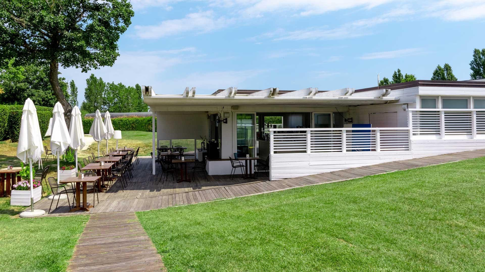 Terrazza estiva con tavoli e ombrelloni bianchi