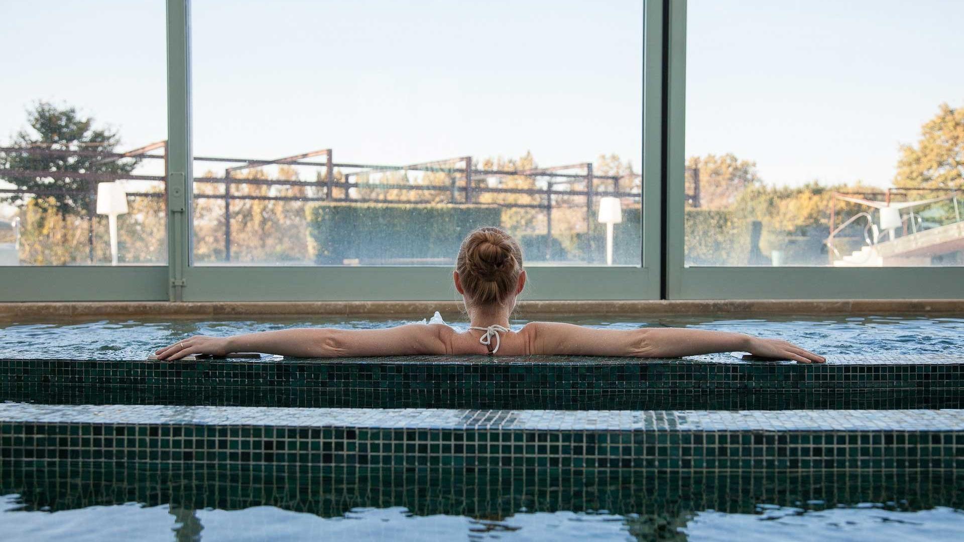 Donna rilassata in piscina termale, immersa nell'acqua