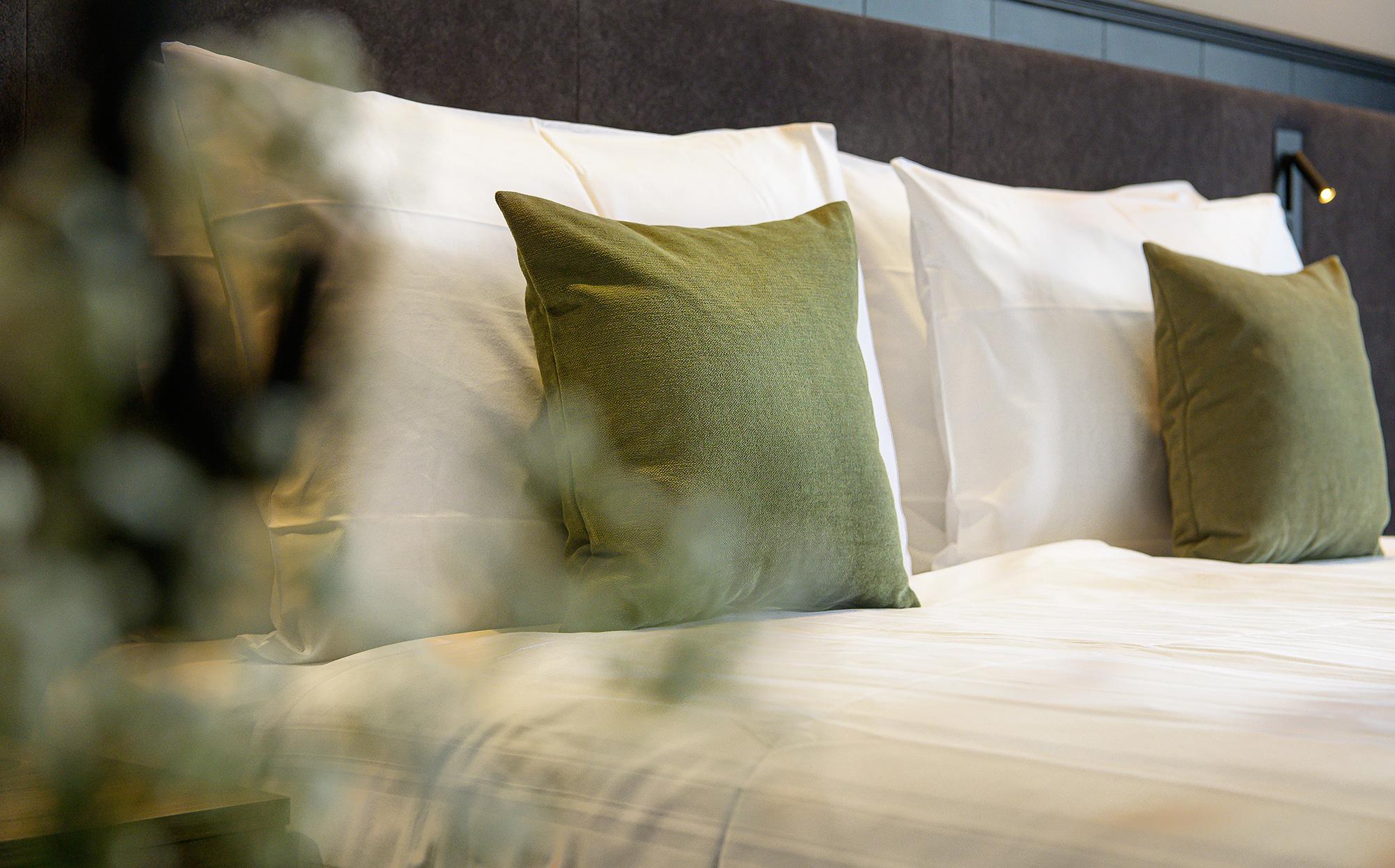 Letto matrimoniale con cuscini verdi